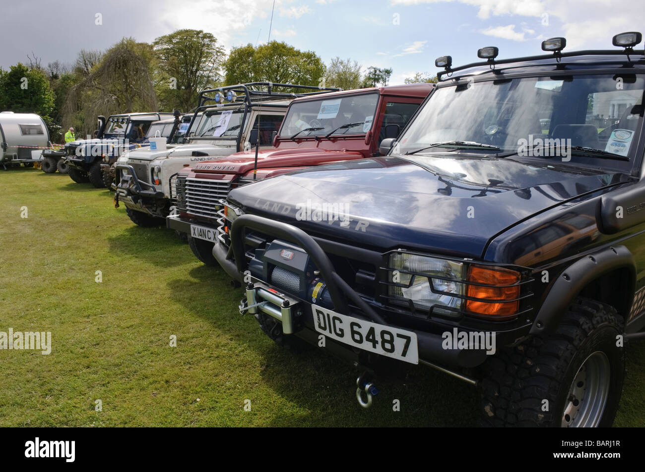 Linie der off Road Landrover geparkt auf einem Feld. Stockfoto
