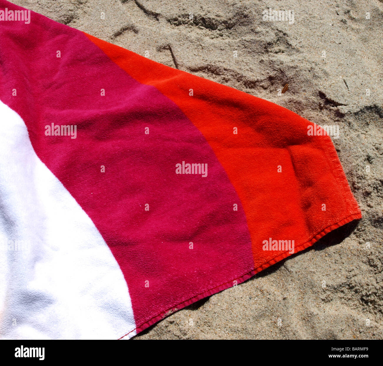 rot und lila Handtuch am Strand Sand Closeup mit weißen Streifen, helle Farben Farben Stockfoto