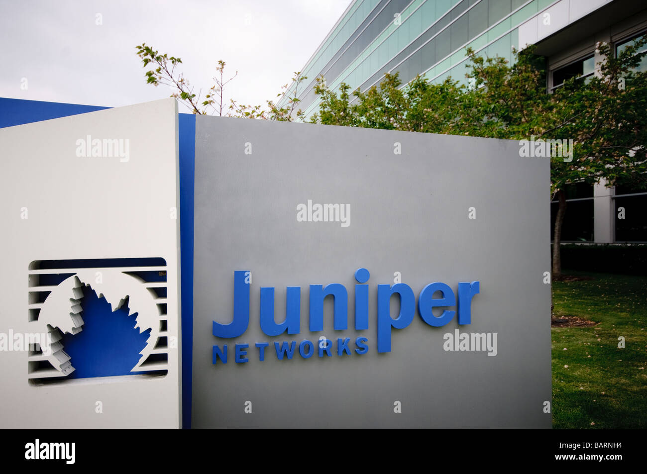 Juniper Networks Zeichen hautnah mit Gebäude hinter. Stockfoto