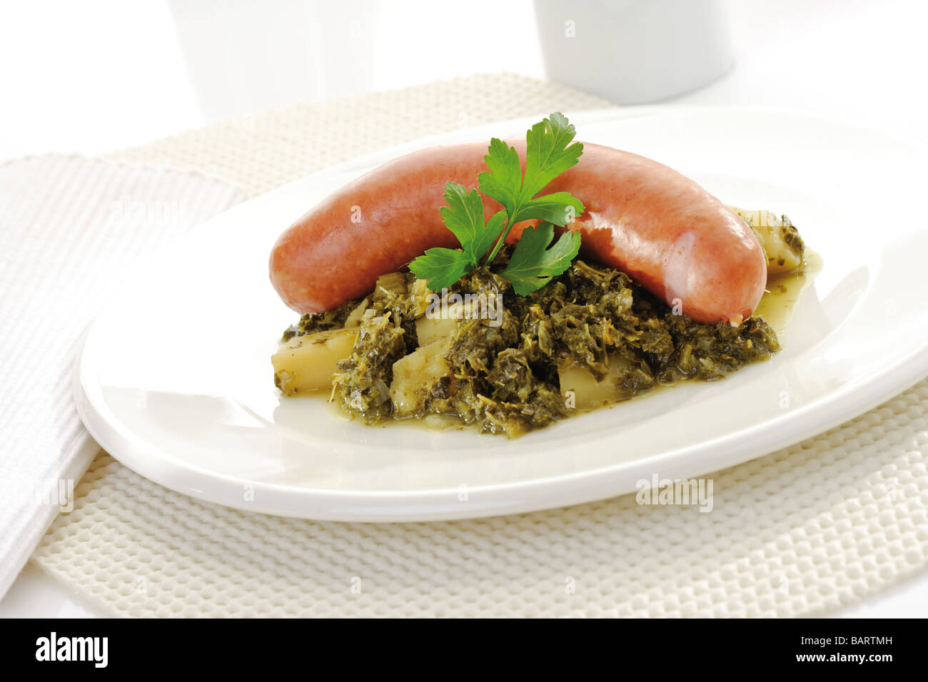 Grünkohl mit Wurst und Kartoffeln auf Teller Stockfoto