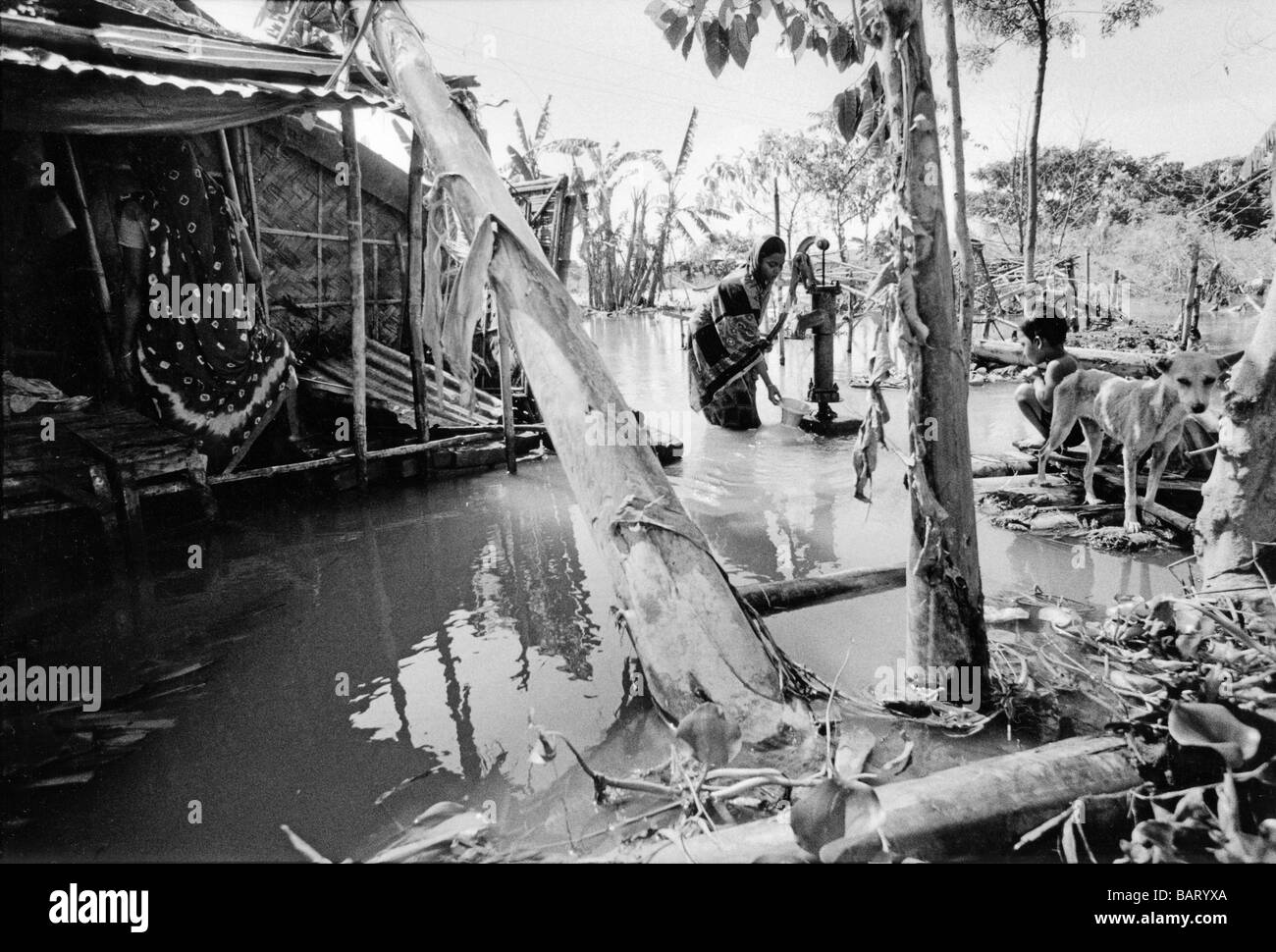 Bangladesch, zeichnet Dhaka eine junge Mutter frisches Wasser aus der Tube gut, das immer noch Trinkwasser trotz Hochwasser liefert. Stockfoto