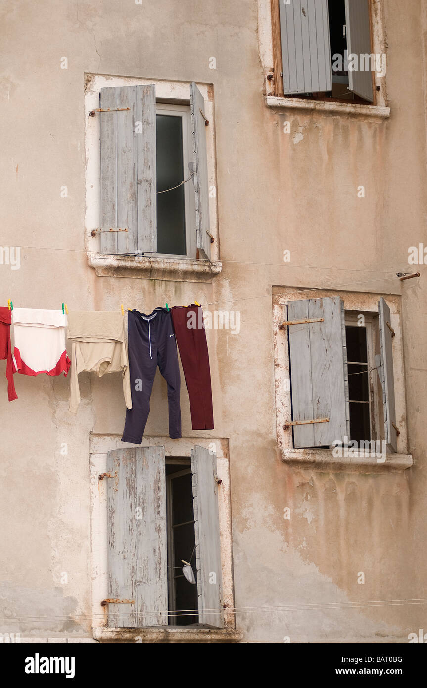 Die Kleidung, die vor den Fenstern eines alten Gebäudes hängt Stockfoto
