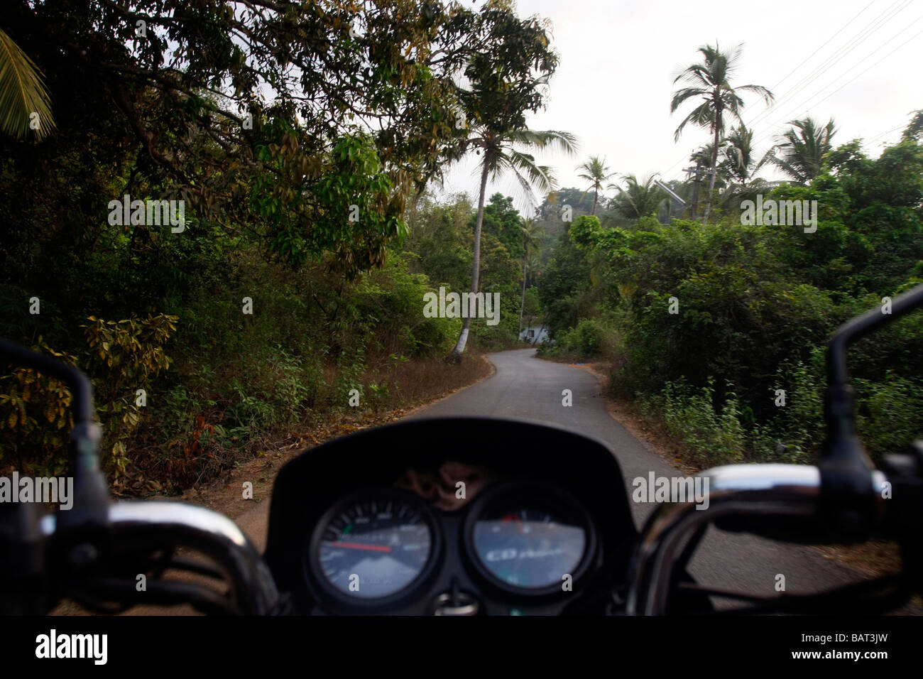 Eine schmale Straße, die aus Sicht des Fahrers auf einem Motorrad in Vagator im nördlichen Goa in Indien gesehen. Stockfoto