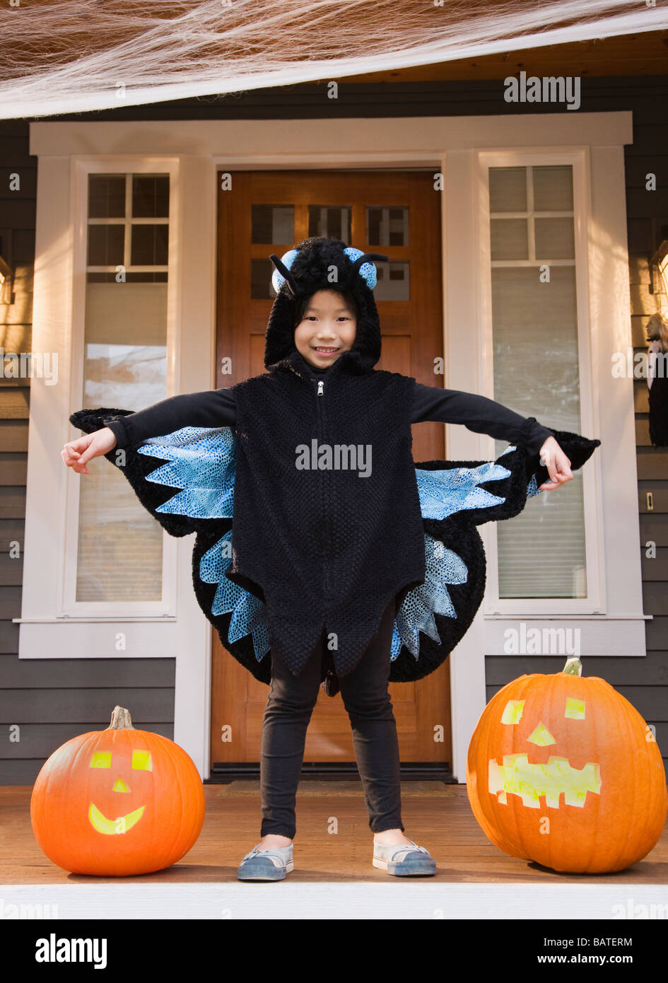 Junge Chinesin in Schmetterling Kostüm mit Halloween-Kürbisse Stockfoto