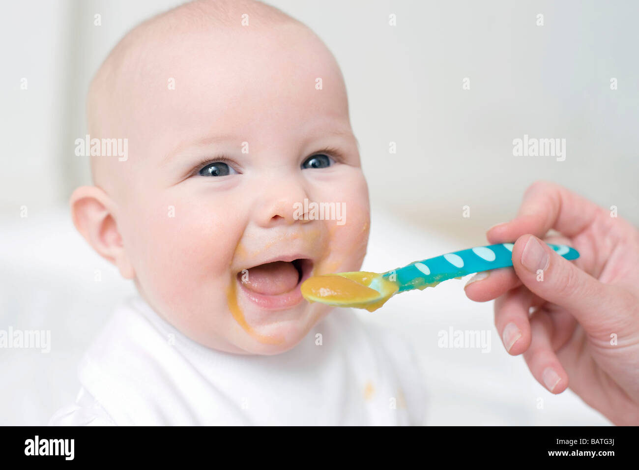 Gängelei. 7 Monate altes Baby Mädchen Löffel gefüttert werden. Stockfoto