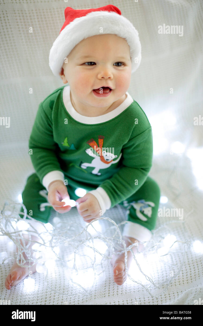 Jungen spielen mit Lichterketten in eine Weihnachts-Outfit gekleidet. Er ist neun Monate alt. Stockfoto