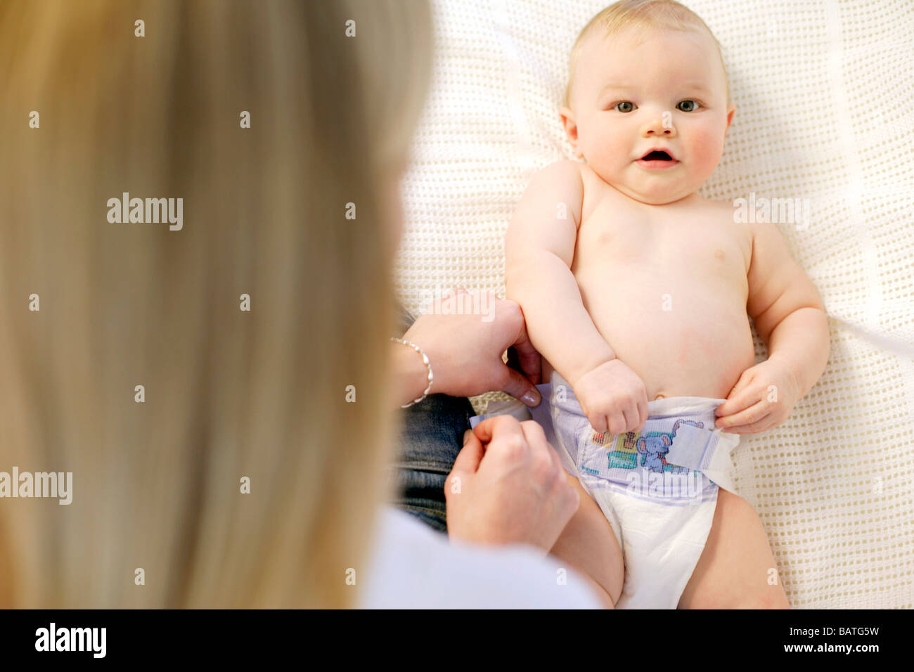 Windel wechseln. Ändern ihr neun Monate altes Baby junge Mutter ist Windel  Stockfotografie - Alamy