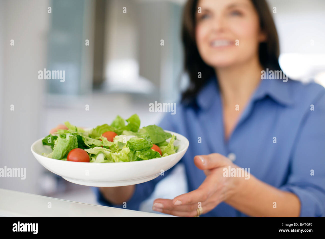 Gesunde Ernährung. Frau hält eine Schüssel mit grünem Salat. Stockfoto