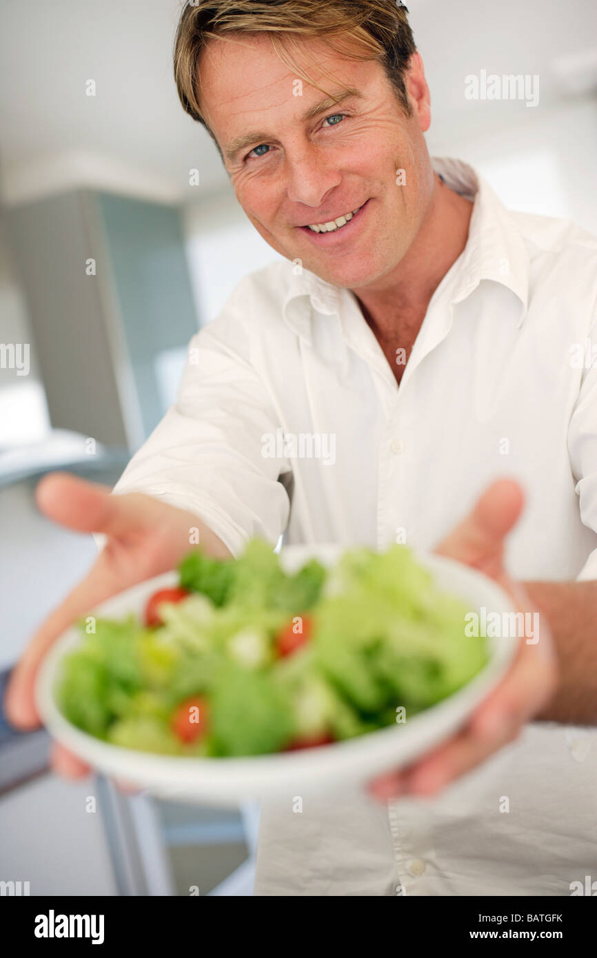 Gesunde Ernährung. Mann hält eine Schüssel mit grünem Salat. Stockfoto