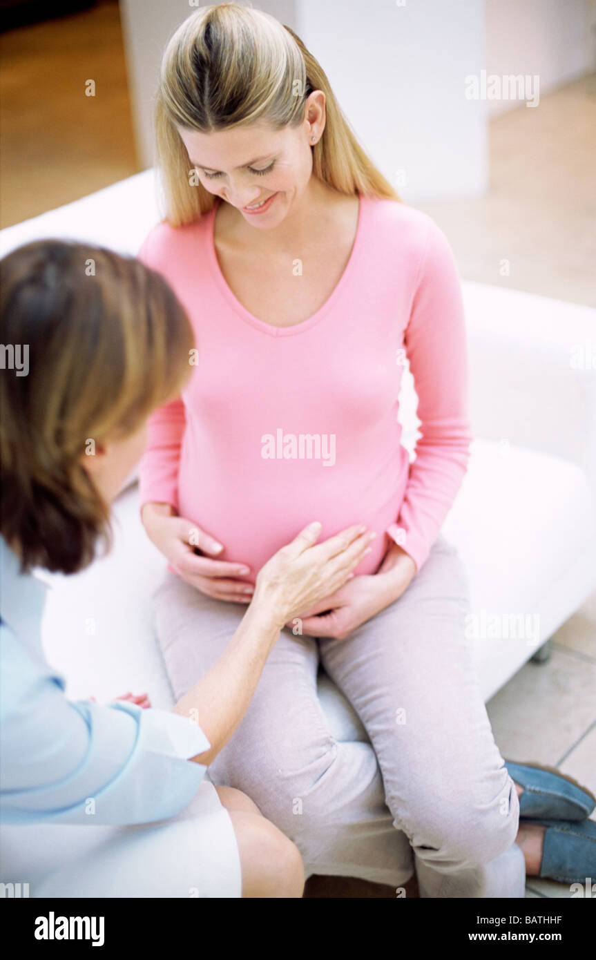 Geburtshilfliche Untersuchung. Hebamme einer schwangeren Bauch zu berühren. Stockfoto