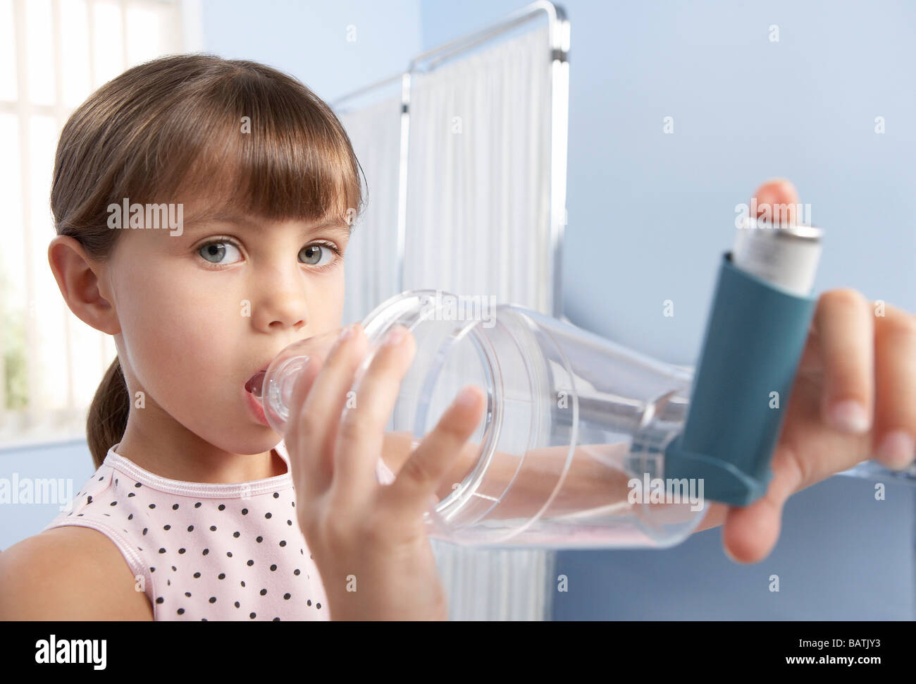 Asthma-Abstandshalter. Junges Mädchen mit ein Distanzstück (Kunststoff Kammer) mit einem Inhalator, um ihr Asthma zu behandeln. Stockfoto