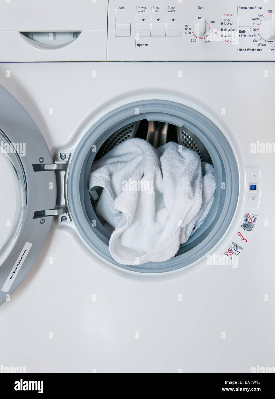 Waschmaschine mit Wäsche herausragen, Nahaufnahme Stockfoto