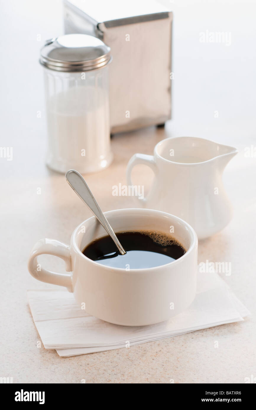 Tasse Kaffee mit Milch und Zucker auf Tisch Stockfoto