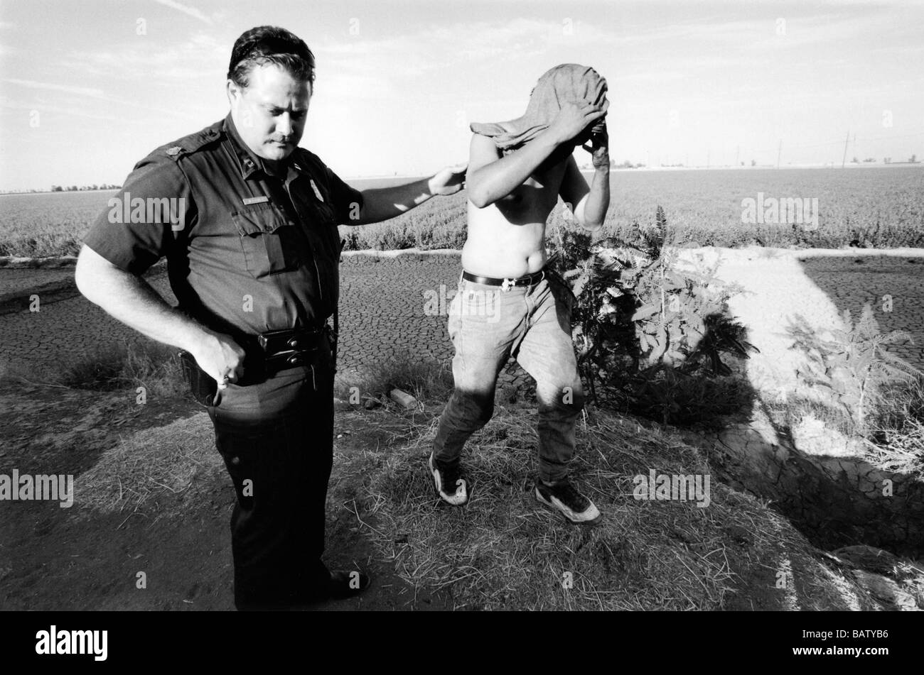 US-mexikanischen Grenze Calexico USA A uns Border Patrol Agent bringt in ein illegaler Einwanderer hat er nur gefunden versteckt in einem Feld Stockfoto
