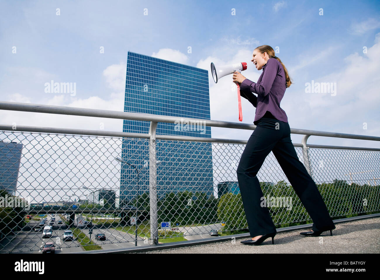 junge Geschäftsfrau auf Brücke über Megaphon schreien Stockfoto