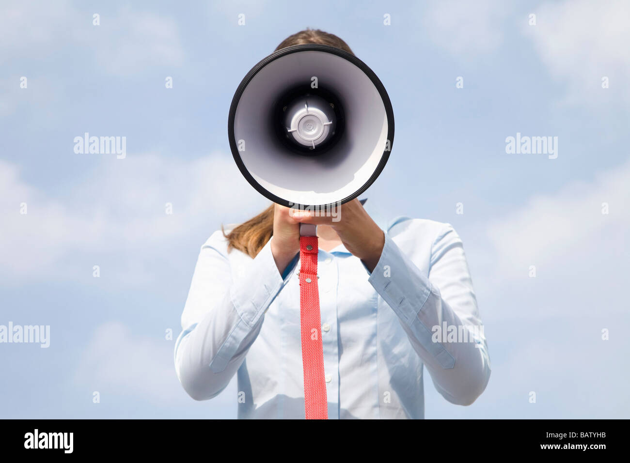 Porträt des jungen Geschäftsfrau versteckt hinter Megaphon Stockfoto