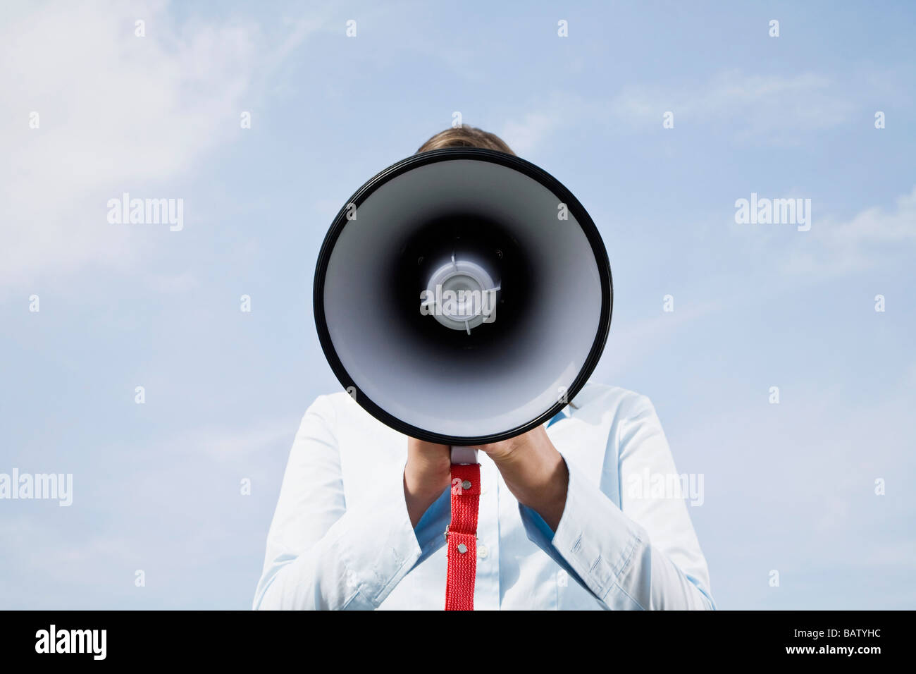 Porträt des jungen Geschäftsfrau versteckt hinter Megaphon Stockfoto