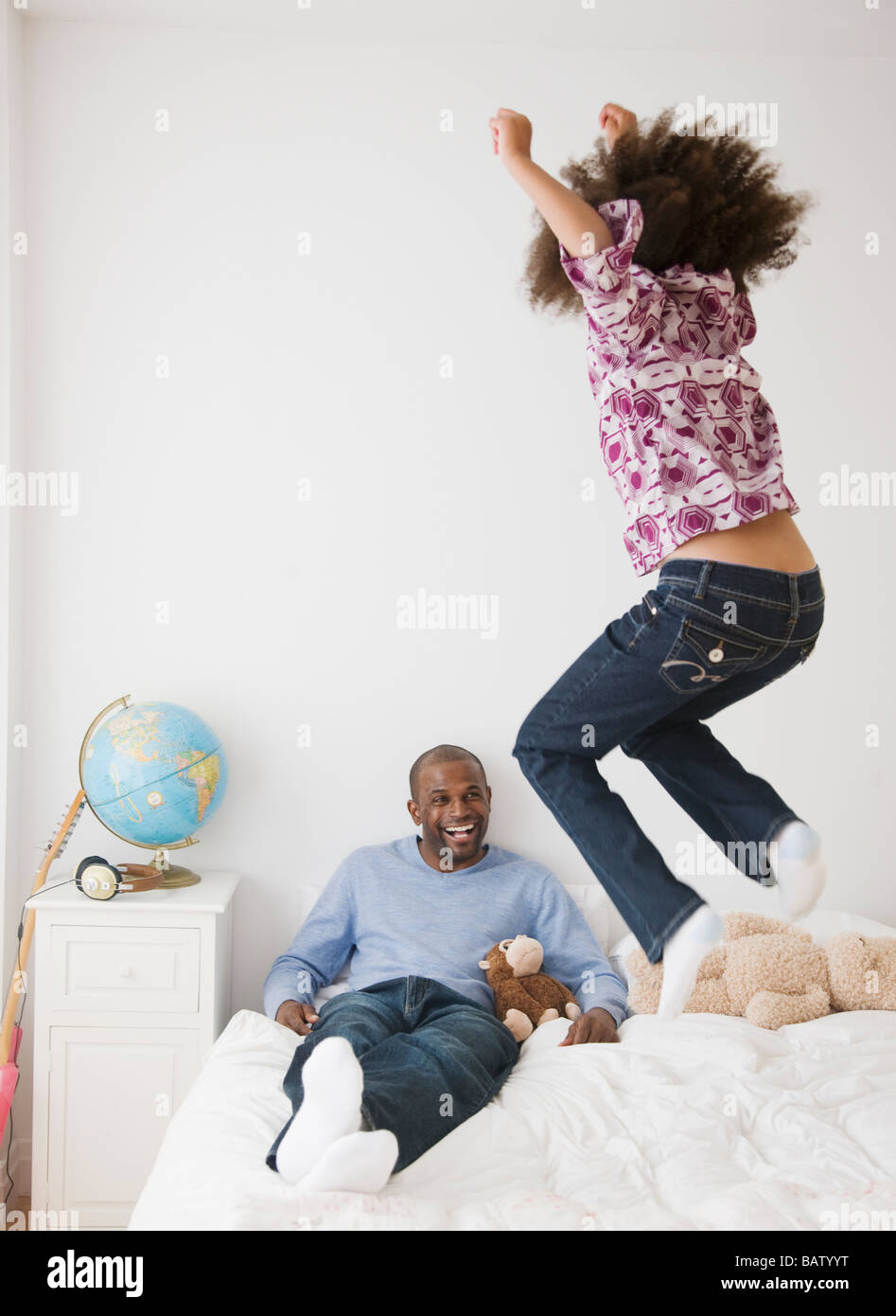 Afrikanischen Vater und Tochter spielen auf Bett Stockfoto