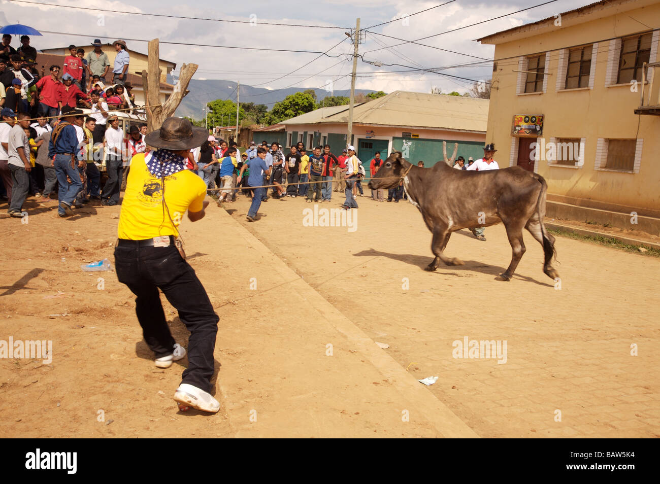 Ein Mann hält einen Stier an einem Seil in Vorbereitung auf den Ring betreten, während die Menge den Stier durch schreien verhöhnen Stockfoto