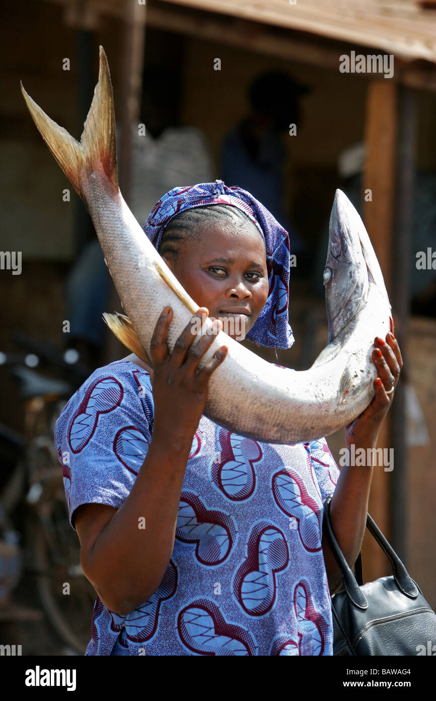 Frau mit Baracuda Fisch auf die Fische markiert in Kamsar, Guinea, Westafrika Stockfoto