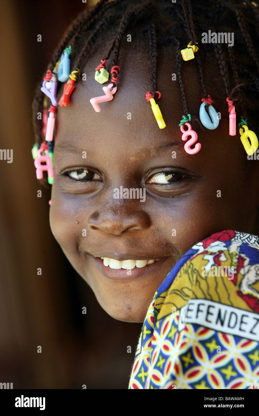 lächelndes Mädchen mit Buchstaben in ihre Dreadlocks, Guinea, Westafrika Stockfoto