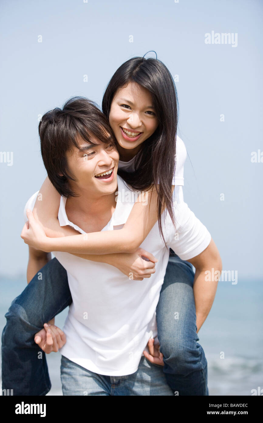 Junger Mann mit junger Frau am Strand Stockfoto