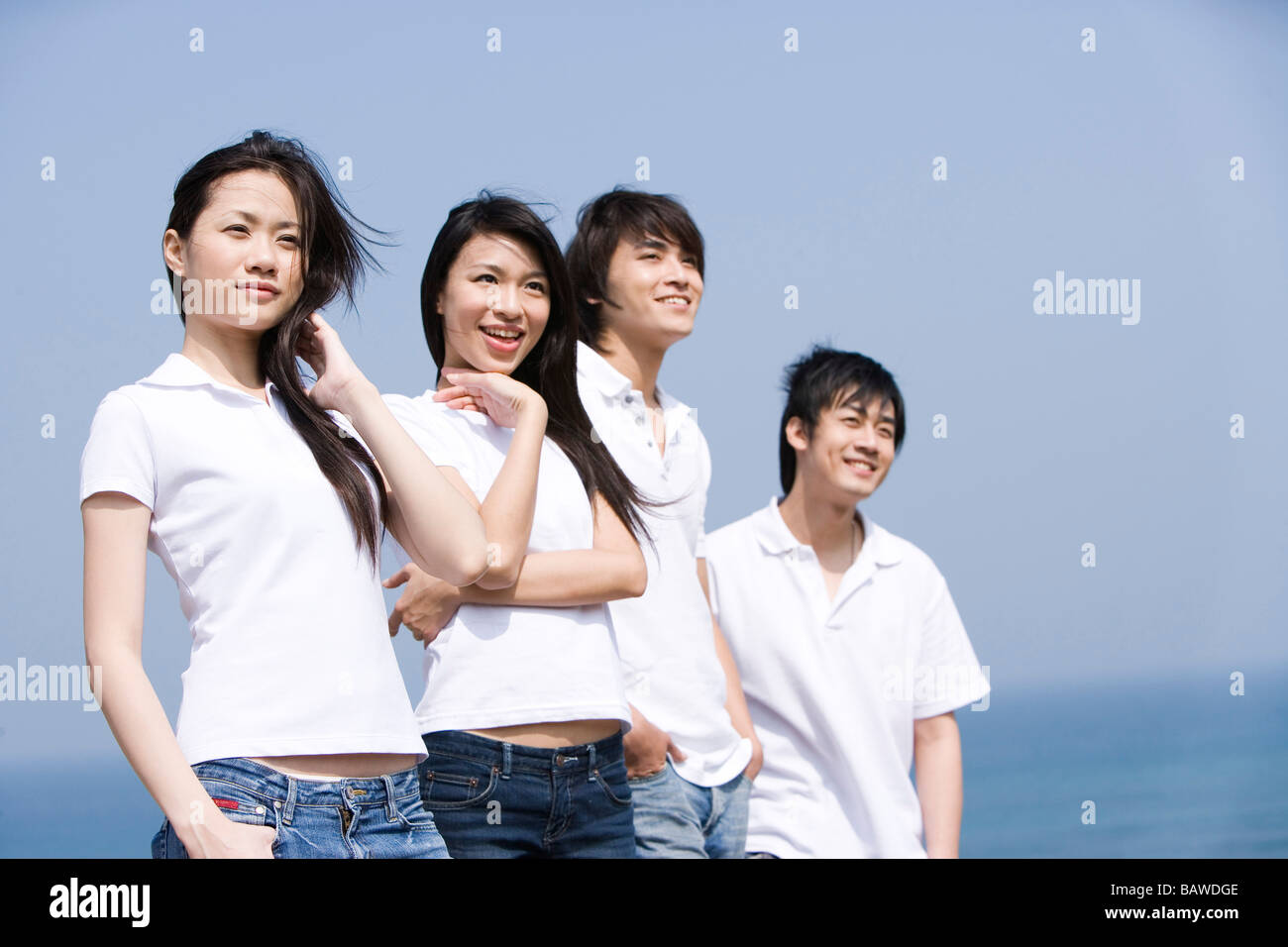 Vier junge Erwachsene, die in einer Reihe Stockfoto