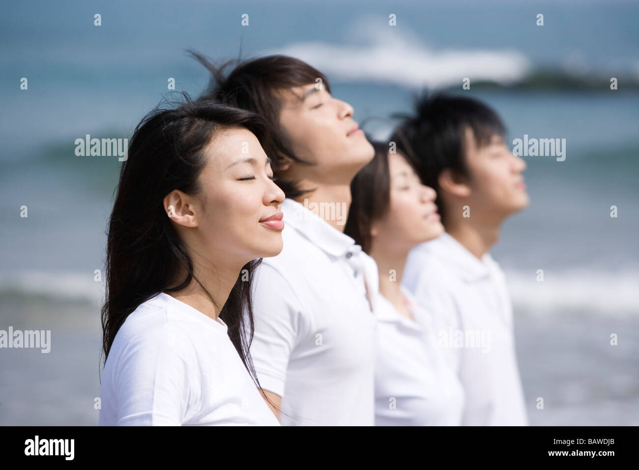 Vier junge Erwachsene stehen in einer Zeile zu meditieren Stockfoto