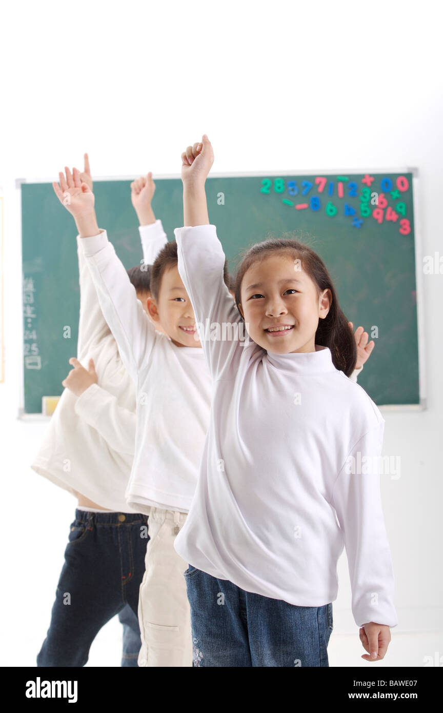 Studenten, die Hände im Klassenzimmer Stockfoto