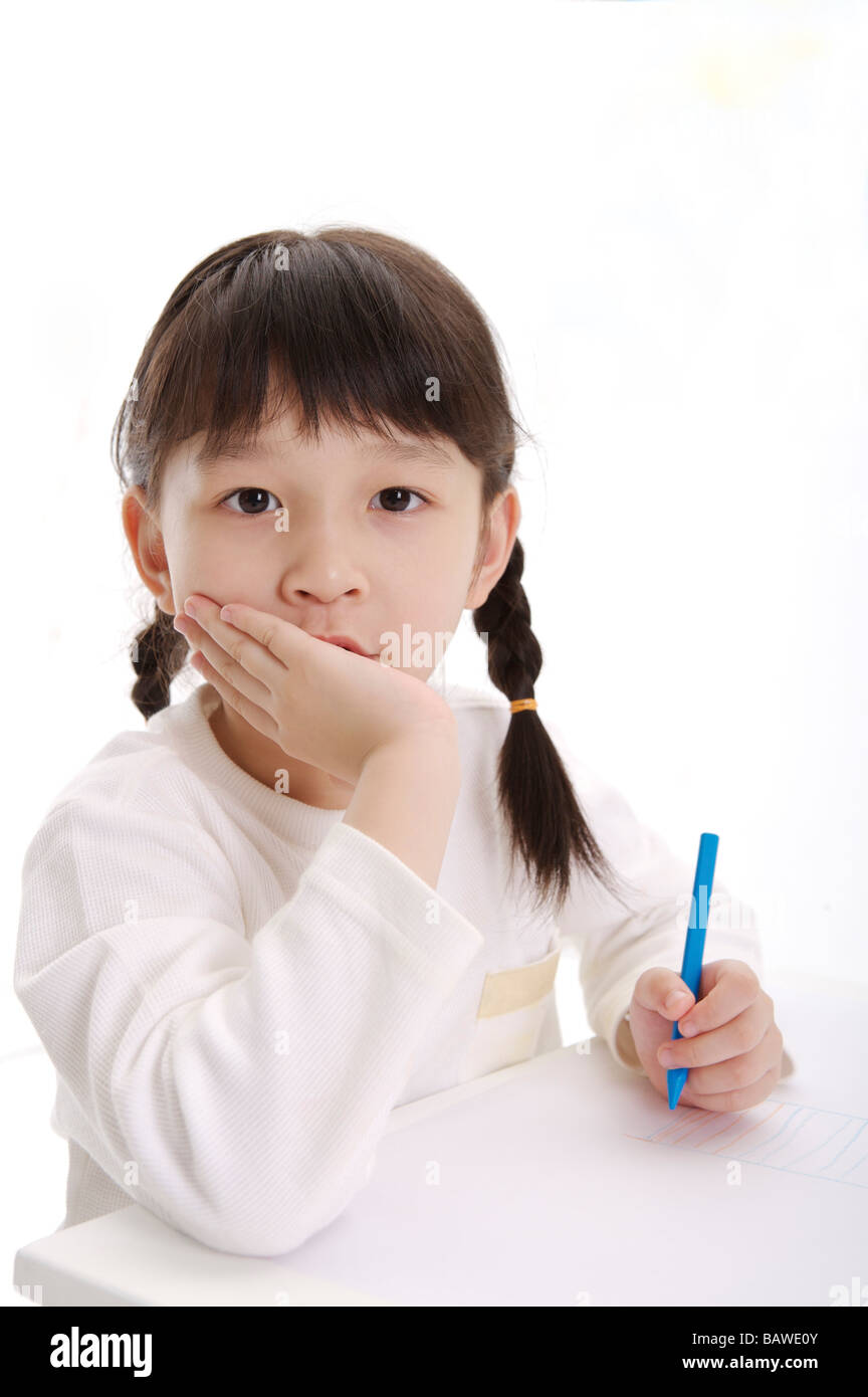 Mädchen-Rest Kinn in die Hand im Klassenzimmer Stockfoto