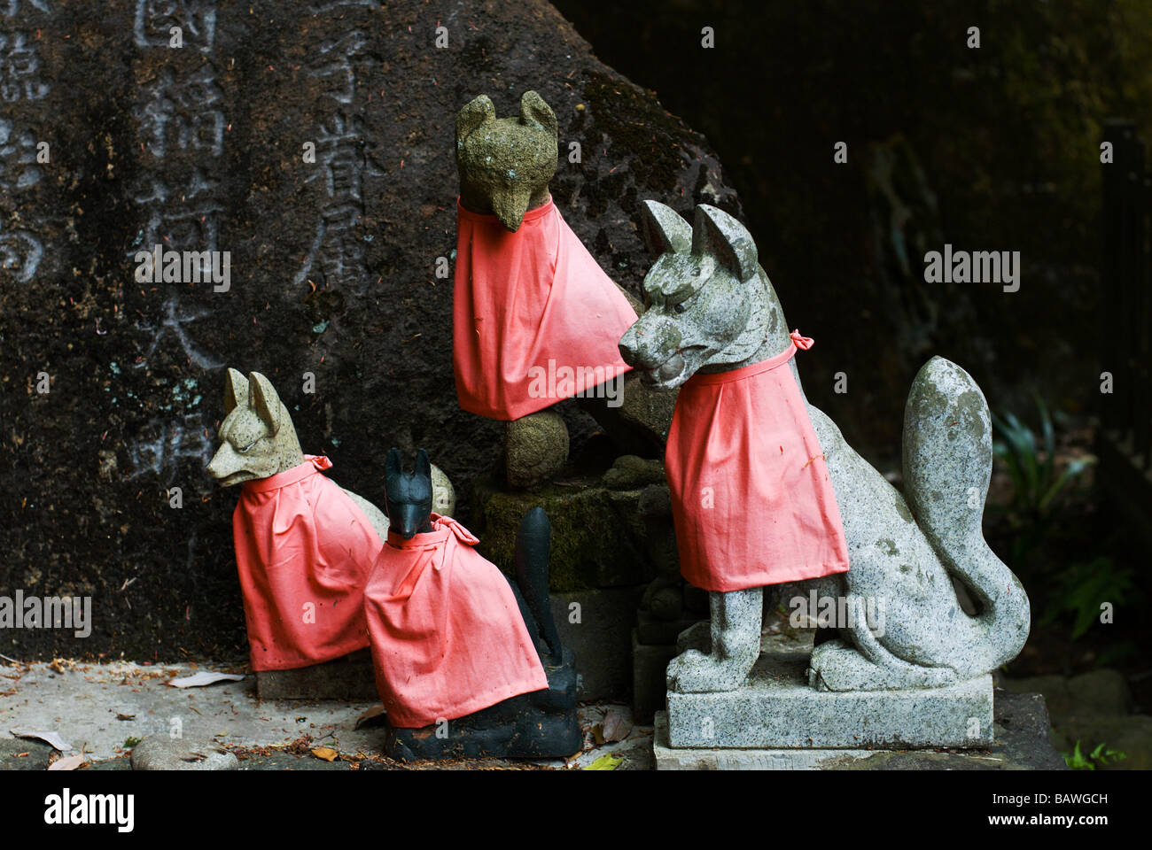 Inari fox Statuen in roten Lätzchen am kleinen Shinto Inari Schrein auf Mount Takao, Tokio Stockfoto