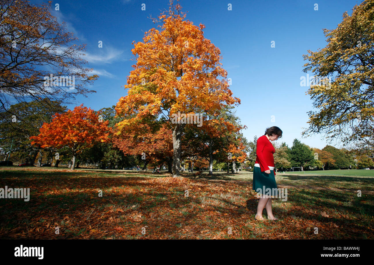Eine junge Frau trägt einen Rock Spaziergänge durch den Park während der Herbstsaison in Victoria, BC, Kanada. Stockfoto