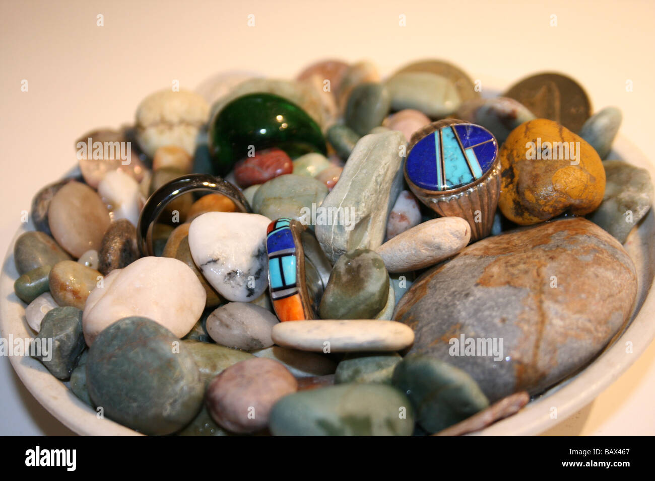 Mondsteine von Moonstone Beach, Zentral-Kalifornien in einer China-Schüssel mit Silberringe inmitten von Lapis und Muschel gesammelt. Stockfoto
