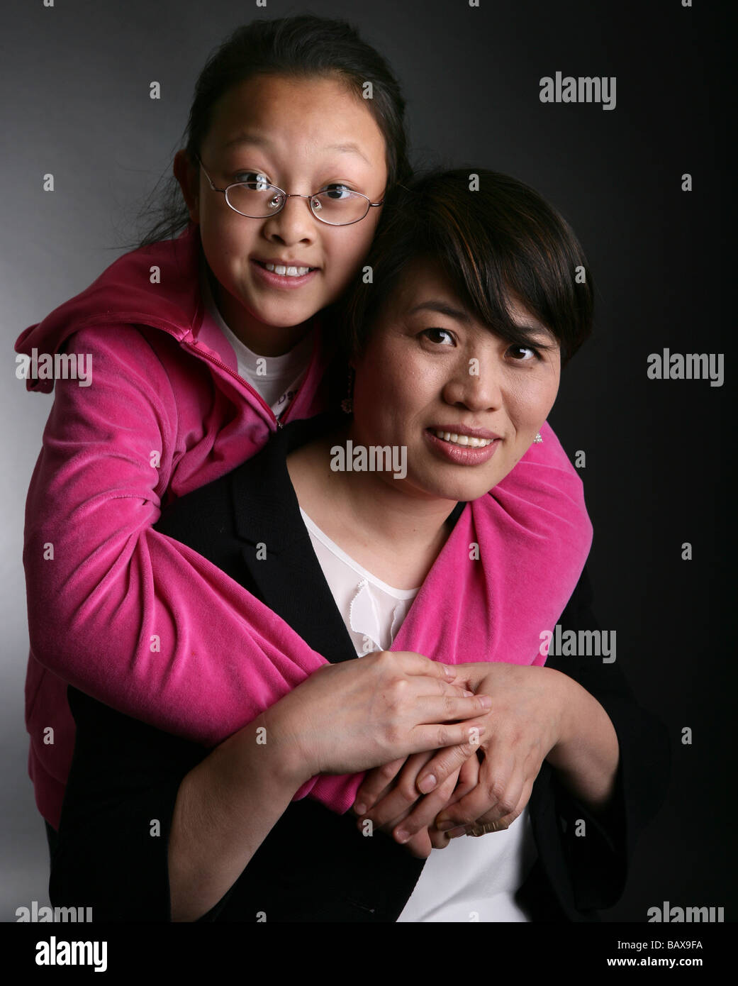Eine Mutter und Tochter in einer Situation Studion, lächelnd und glücklich. Mutterschaft-Konzept. Stockfoto