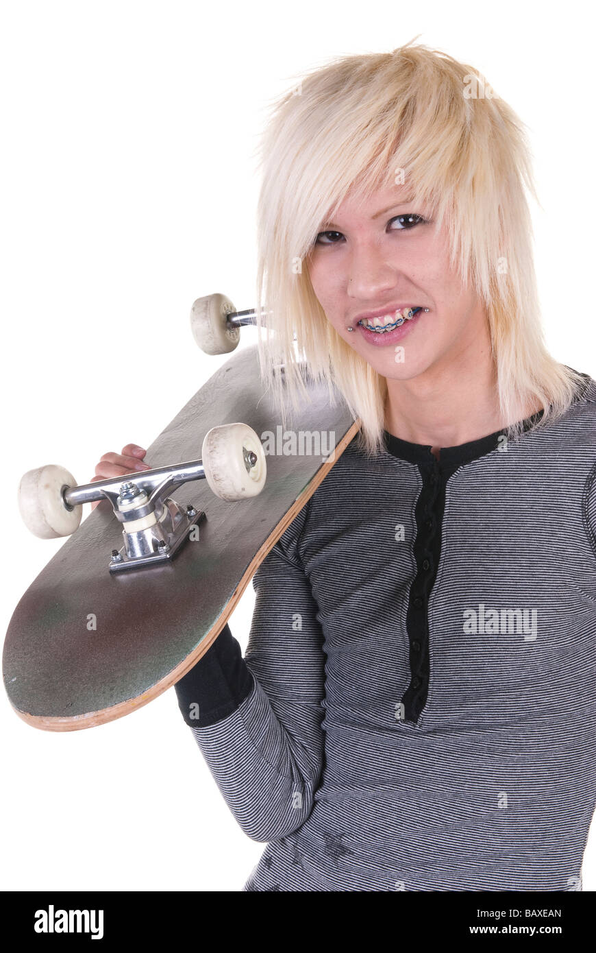 Eine blonde Teenager Skateboarder mit geschweiften Klammern mit seinem Skateboard zeigt moderne Jugendkultur Stockfoto
