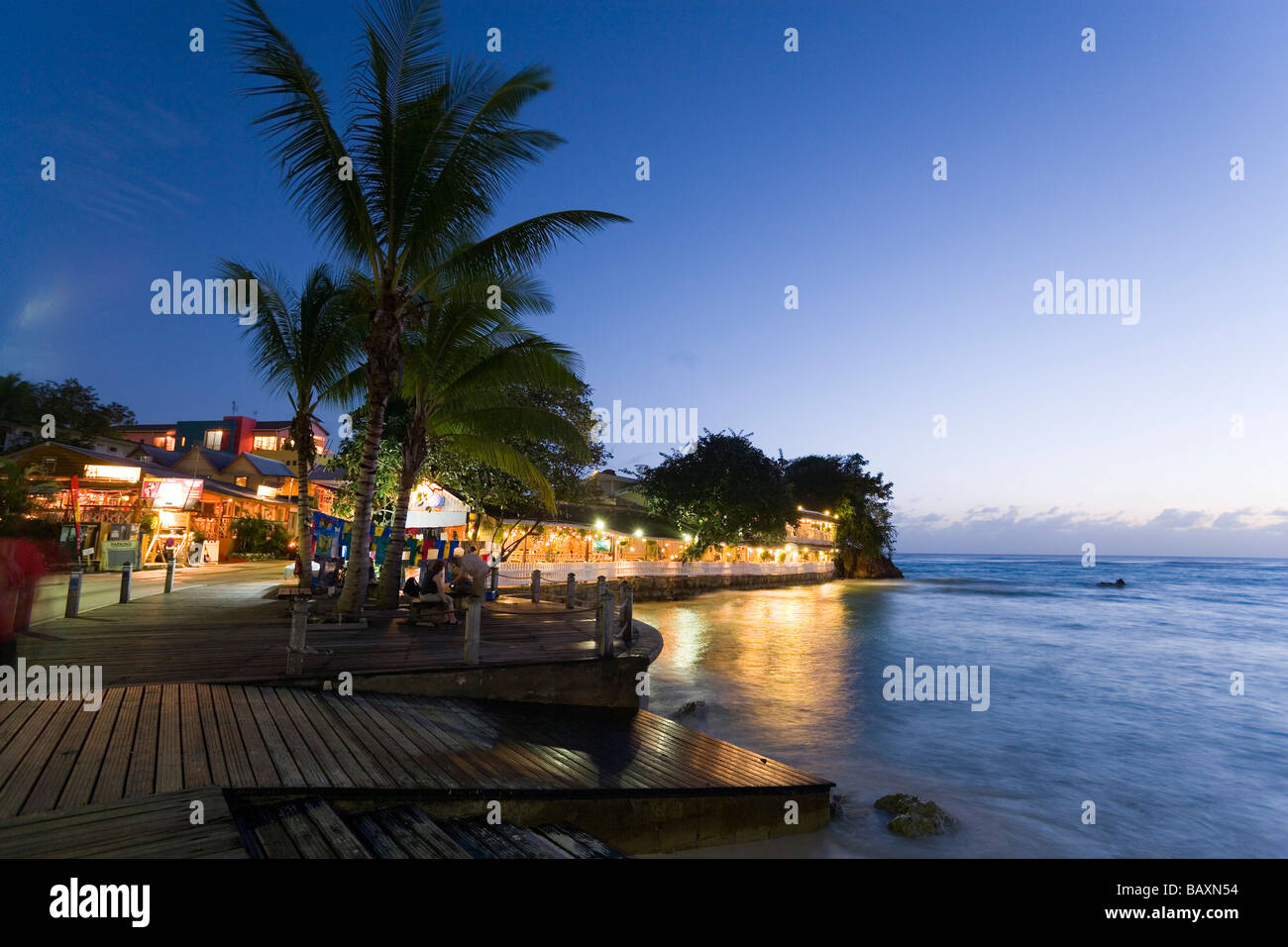 Touristen auf der Promenade neben Fisch-Restaurant am Abend, St. Lawrence Gap, Barbados, Caribbean Stockfoto