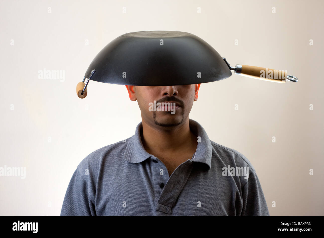 Mann mit Wok auf Kopf isoliert auf weiss Stockfotografie - Alamy