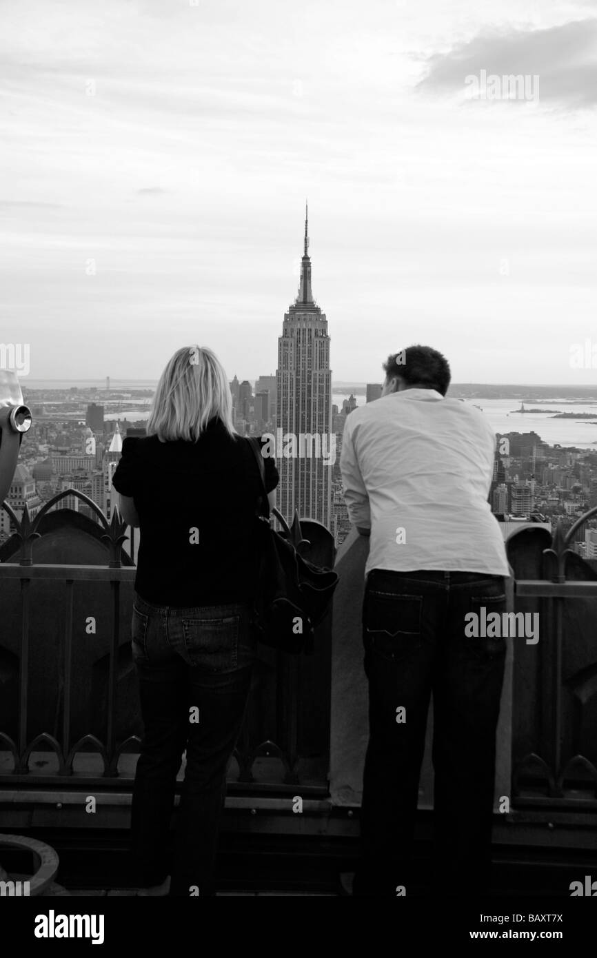 Ein paar auf der Oberseite der Rock Aussichtsplattform Rockefeller Center in New York mit Blick auf das Empire State Building. Stockfoto
