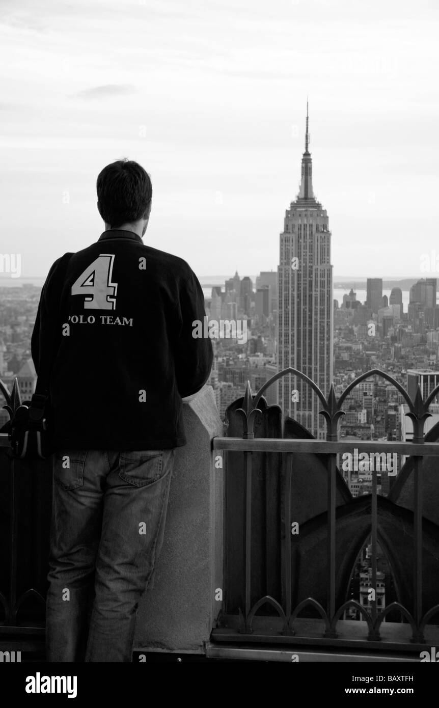 Ein Tourist auf der Spitze der Felsen, Rockefeller Center, New York mit Blick auf das Empire State Building. Stockfoto