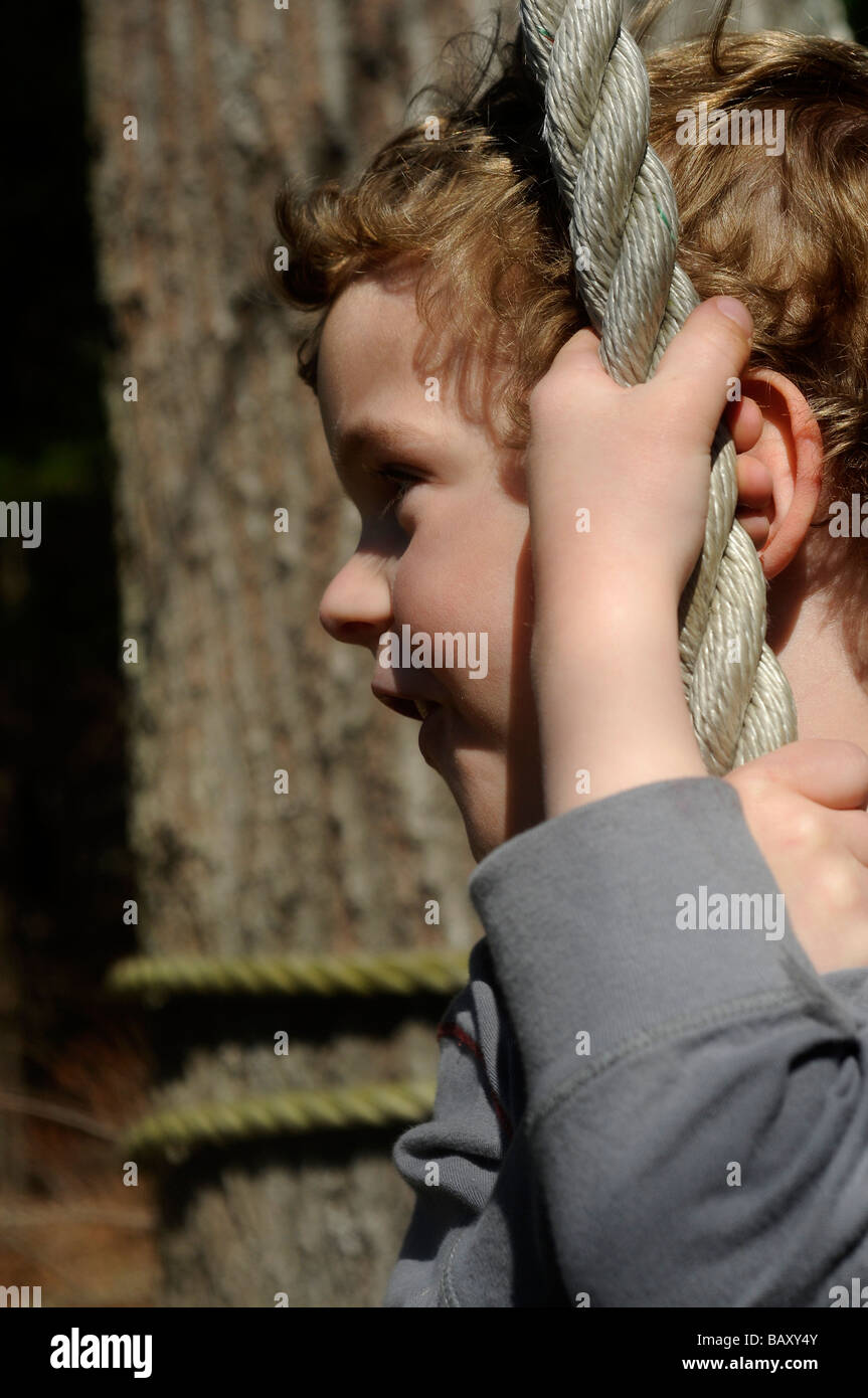 Blonde junge hängende Seil und schwingen Stockfoto