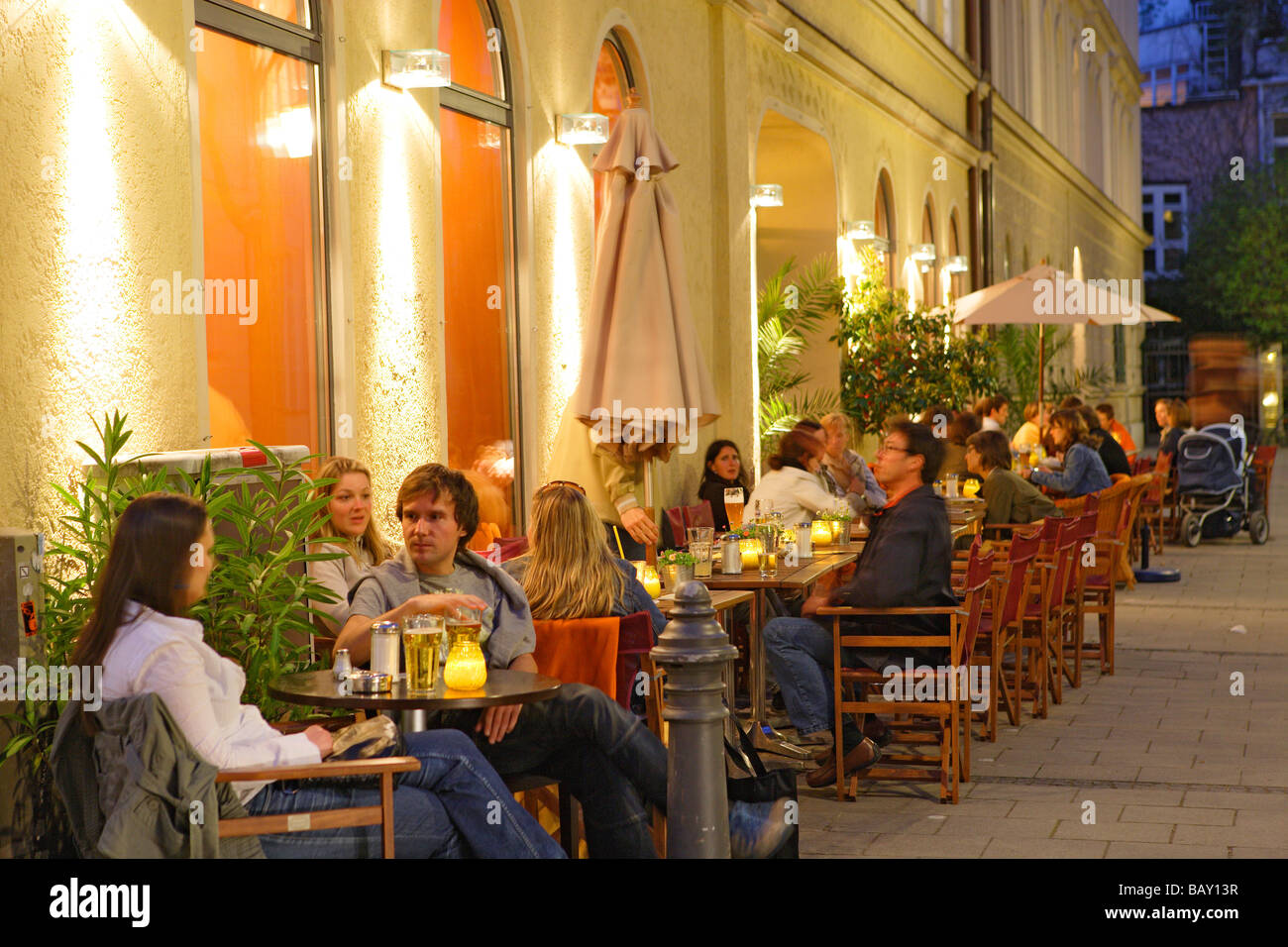 Menschen sitzen vor Cafe Zeitgeist in der Abend, Maxvorstadt, München, Bayern, Deutschland Stockfoto