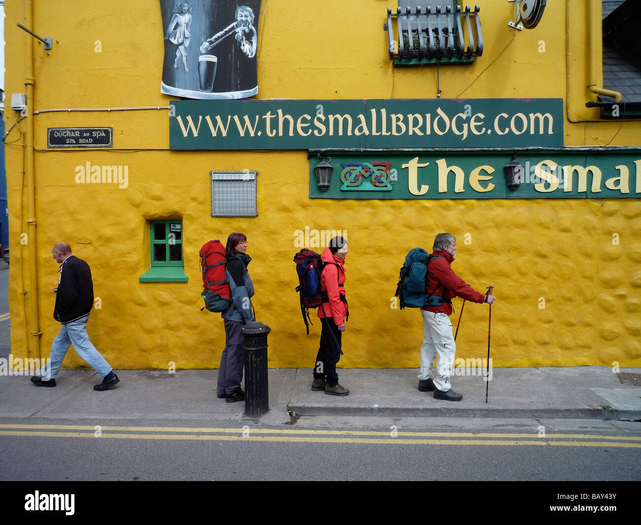 Wanderer zu Fuß der Dingle Way vor einem bunten Pub, Halbinsel Dingle, Dingle, County Kerry, Irland Stockfoto