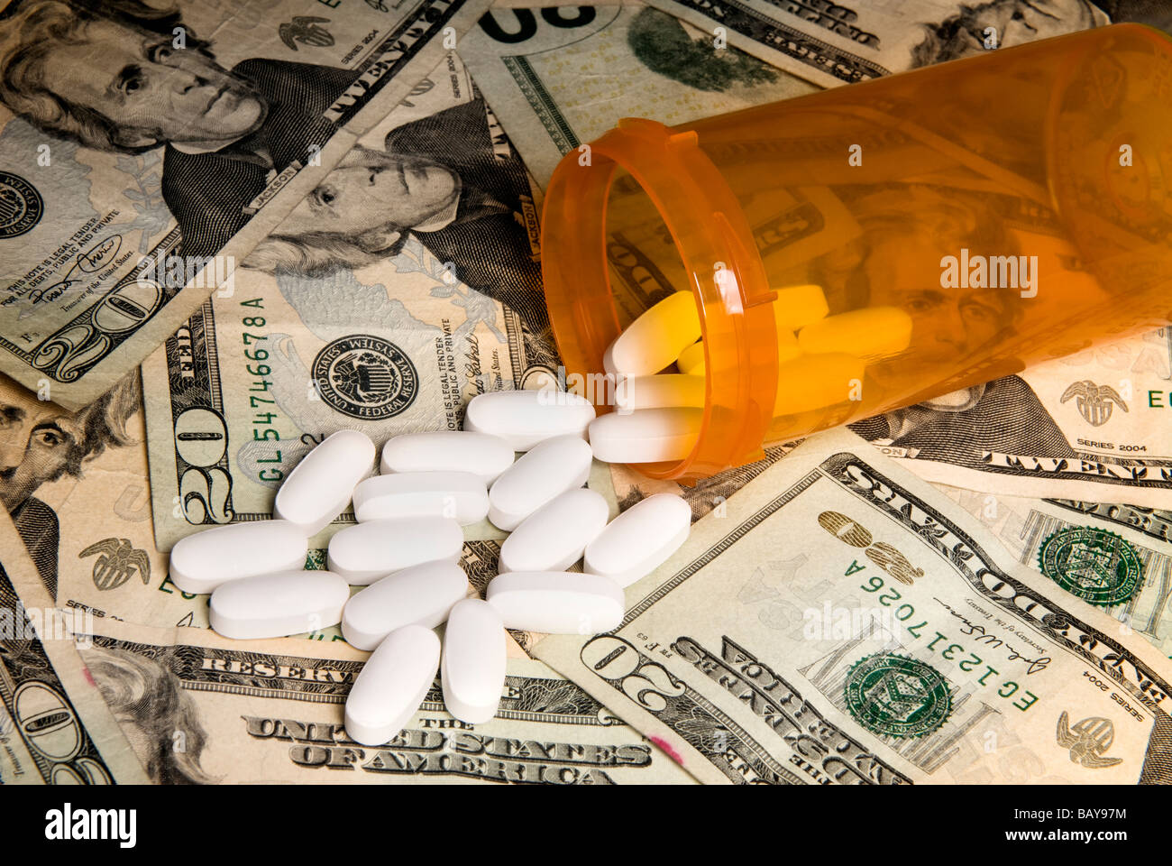 Medikamente aus einer Pille Flasche verschüttete auf Bargeld. Verwendung für jede Art von medizinischen Versicherung oder finanzielle Schwierigkeiten Folgerung für Medikamente Stockfoto