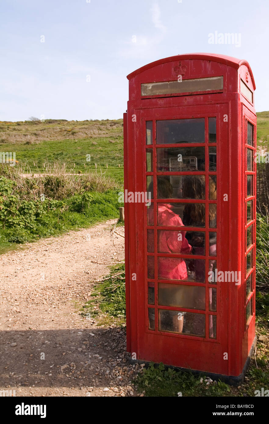 Kinder mitgehen in öffentliche Telefonzelle in Landschaft Stockfoto