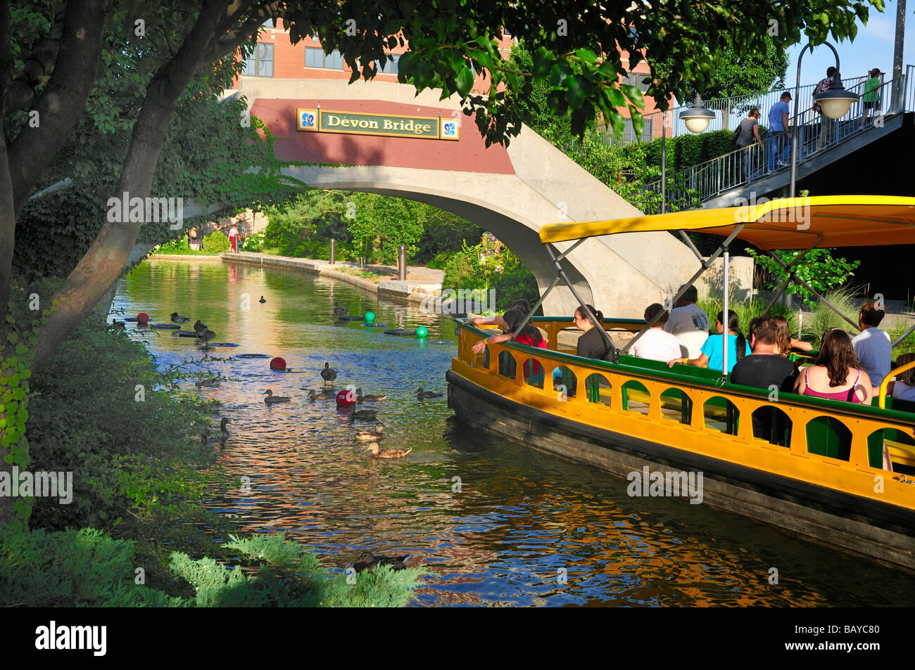 Ein Wassertaxi bringt Besucher unter der Devon-Brücke in Oklahoma City s Bricktown Stockfoto