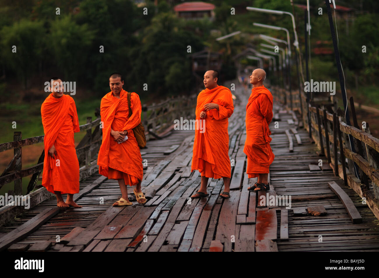 Mönche auf Holzbrücke über Kheuan Khao Laem Stausee Sangkhlaburi thailand Stockfoto