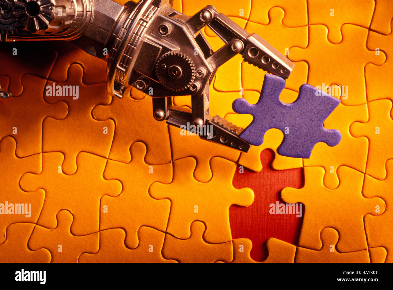 Roboterarm mit Jigsaw Puzzlestück Stockfoto