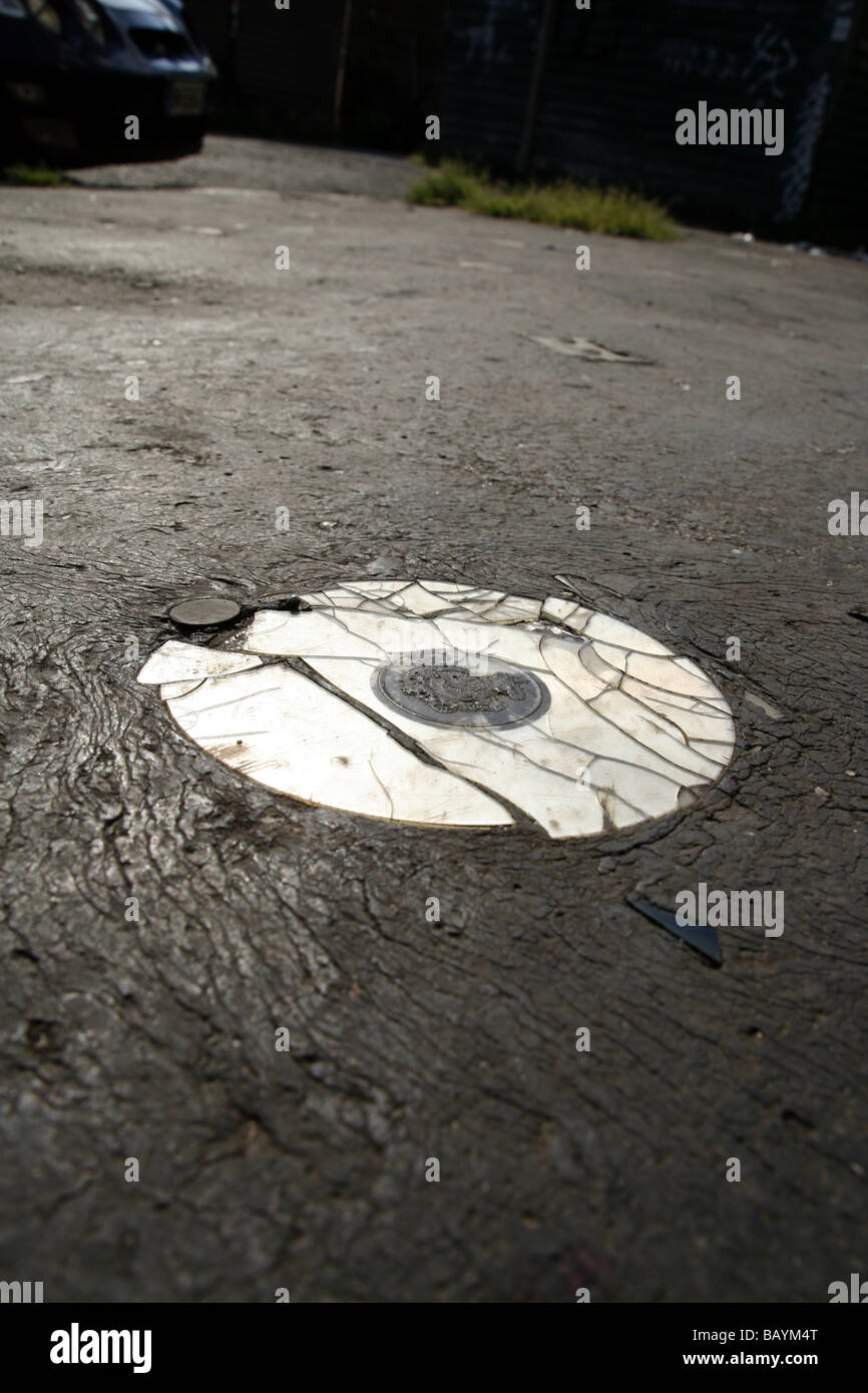 eine alte beschädigte cd Compcat Disk auf Fahrbahn Stockfoto