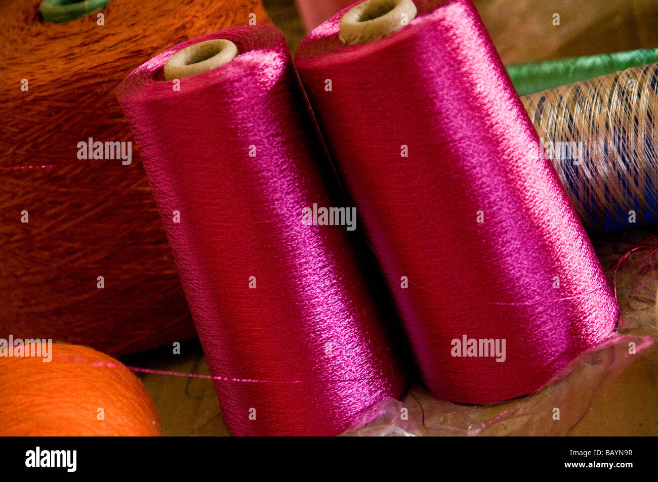 Lebendige rosa und orange Seidenfäden ein Weber Werkstatt, in der Medina. Stockfoto