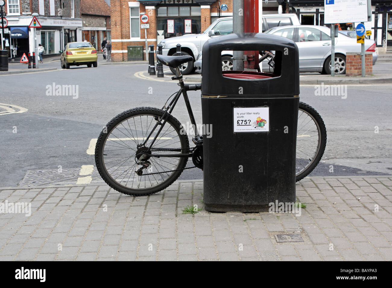 Fahrrad links neben einem Abfallbehälter Stockfoto